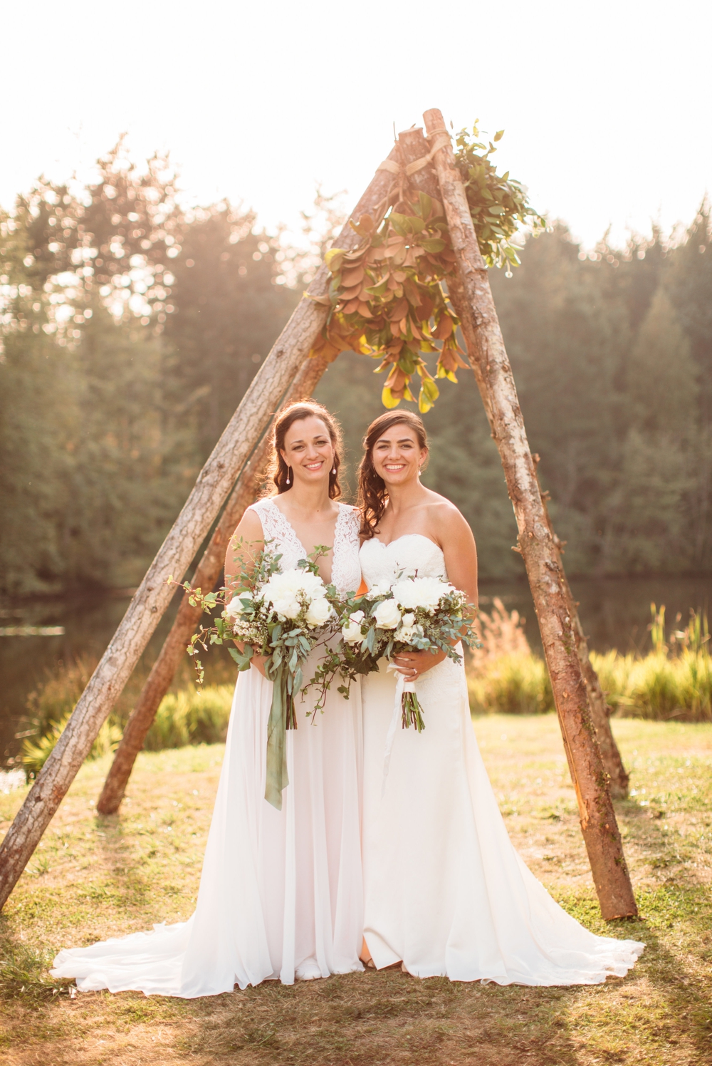 brides-hold-white-bouquets-by-wedding-teepee